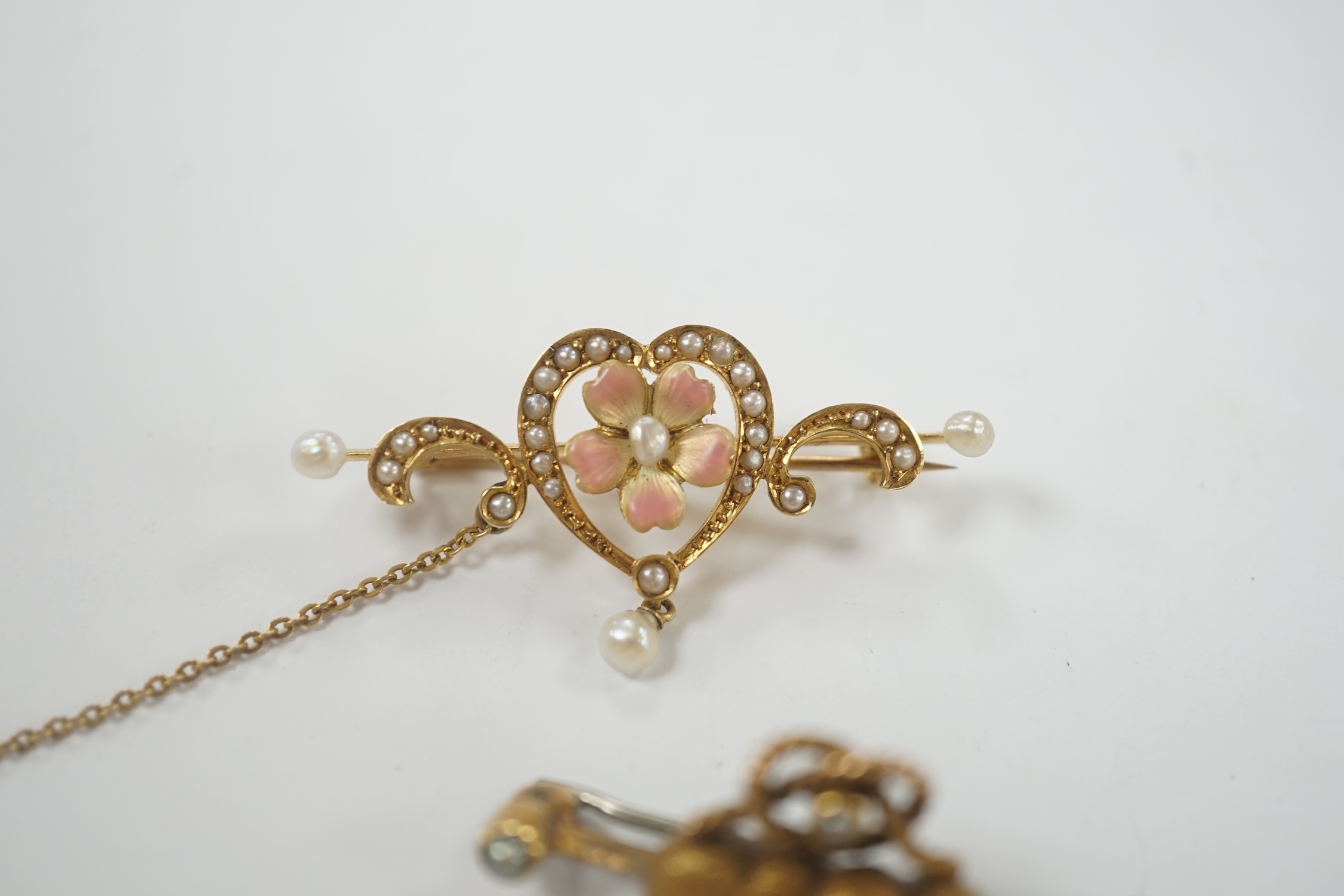 An Edwardian 625 yellow metal, enamel and seed pearl set drop bar brooch, with central heart shaped motif, 40mm, together with a yellow metal and gem set twin hearts bar brooch.